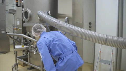 Lab drug factory worker checking and adjusting production steel machines and Stock Footage