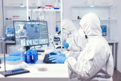 Lab engineer typing on pc conducting experiment in laboratory Stock Photos