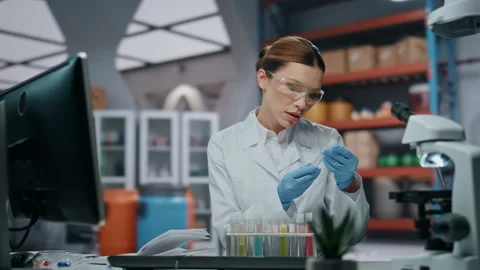 Lab expert checking test tubes making notes in clinic close up. Woman scientist Stock Footage 254622620
