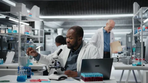 Lab expert using laptop to investigate blue liquid polymer properties Stock Footage 326368177