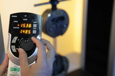 A lab operator handing a stress test machine to gauge a material s resistance Stock Photos