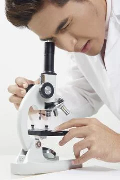Lab personnel looking through a microscope Stock Photos