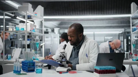 Lab researcher looking through scientific microscope lens to study cells Stock Footage 326263167