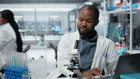 Lab researcher using laptop software to evaluate compound solutions Stock Footage 325818072