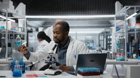 Lab researcher using laptop software to evaluate compound solutions Stock Photos