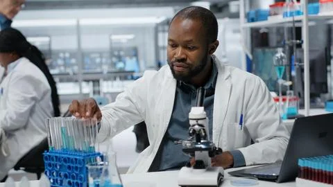 Lab researcher using laptop software to evaluate compound solutions Stock Photos