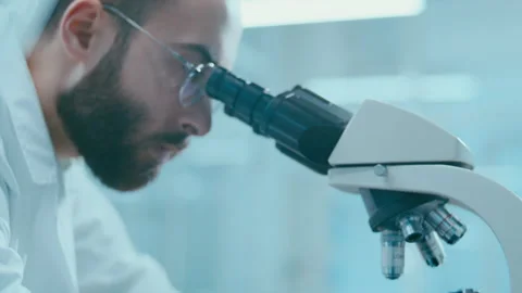 Lab Scientist Adjusting Microscope Focus Knob during Sample Examination Stock Footage 331337309