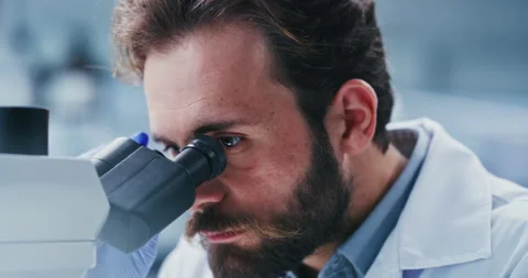 Lab, scientist and man with microscope, exam and analysis for vaccine, serious Stock Footage 330038450