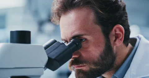 Lab, scientist and man with microscope, study and analysis for vaccine, serious Stock Footage 330038750