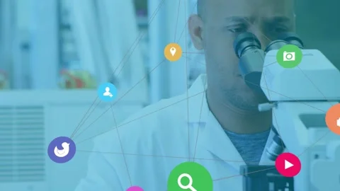 Lab scientist leaning into microscope while icon network moving across scene 動画素材 330380283