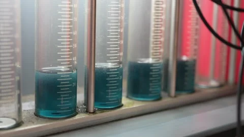 Lab Setup with Blue Liquid in Graduated Cylinders Measurement Stock Footage 347300422