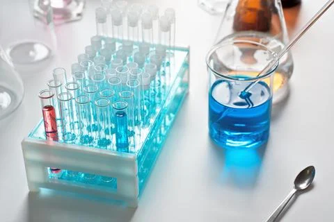 Lab table with test tubes stand and blue liquid in beaker, chemical analysi.. Stock-Fotos
