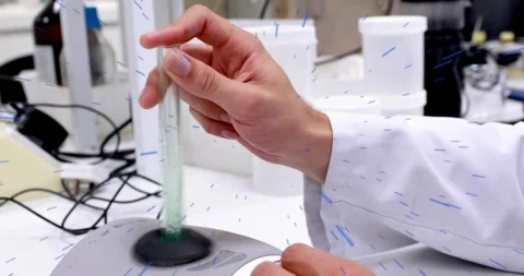 Lab tech hands reaching, placing green test tube into vortex mixer, preparing Stock Footage 330741316
