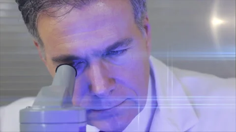 Lab tech looks in microscope with flares Stock Footage