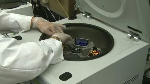 Lab tech removes test tubes from centrifuge Stock Footage 10757521
