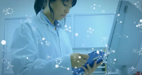 Lab tech tapping blue tablet reviewing data showing network graphics on monitor Stock Footage 331125544
