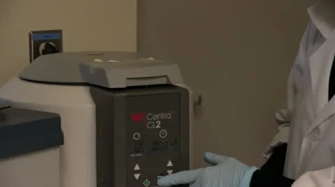 Lab tech turns on centrifuge Stock Footage 21932894