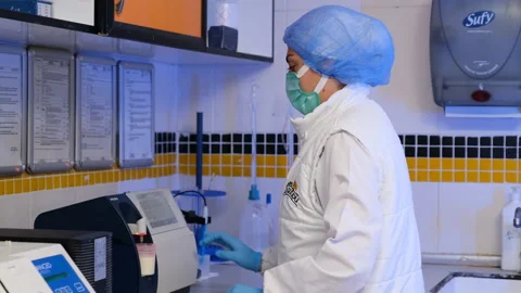 A lab technician in a clean environment preparing a sample Stock-Footage 325330099