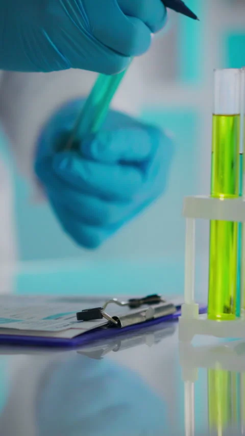 Lab technician conducting an experiment with test tubes and clipboard in a s Stock Footage 331602381