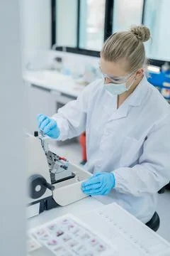 Lab technician conducts analysis with microscope during working hours in a .. Stockfoto's