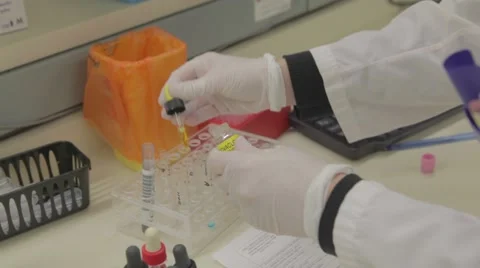 Lab technician drops solution in test tube 库存影片 59799128