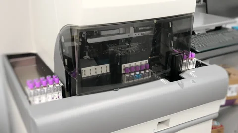 Lab technician loading blood samples into modern automatic analyzer. Vídeo Stock 320886080