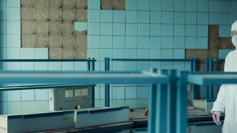 Lab technician in a protective suit and goggles approaches the table in the Video stock 131735953