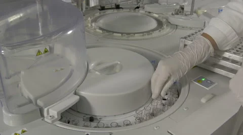 Lab technician putting test tubes with blood samples in clinical modern device Stock Footage 58949987