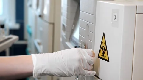 Lab technician scanning test tubes before automated analysis. Stockbeeldmateriaal 347782013