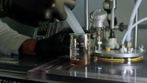 Lab Technician Transfers Organic Liquid Sample for Analysis in Beaker Stock Footage 346622837