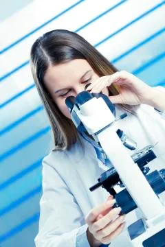 Lab technician using microscope Stock Photos