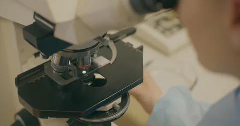 Lab Technician Using Microscope in Virus Research Stock Footage 318106236