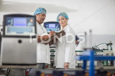 Lab Technicians Checking Equipment At Packaging Factory Lab