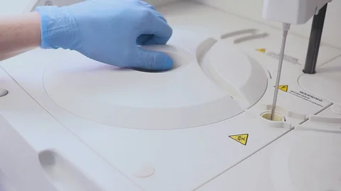 A lab worker doing a blood test. loads the tubes into the machine. The assistant Video stock 101601259