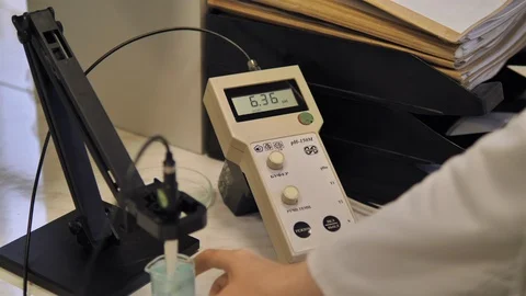 Lab worker hands doing laboratory testing with chemical liquid in beake. 库存影片 128456380