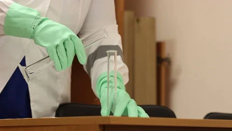 Lab worker hands doing laboratory testing with chemical liquid in beaker Stock Footage 135084599