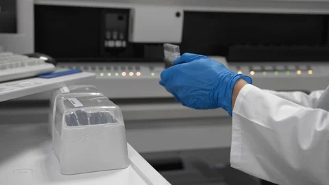 Lab worker installs form with test tubes of medical samples into medical device Vídeos de archivo 88997435