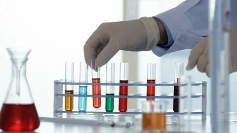 Lab worker pours chemicals from a flask into a test tube Stock Footage 88378701