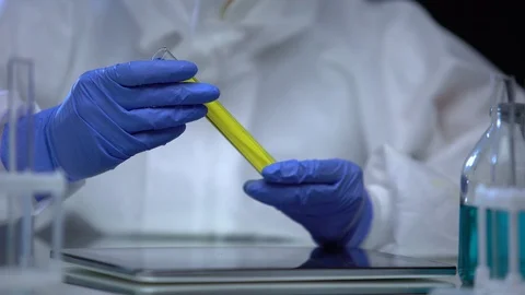 Lab worker in protective suit researching flammable sample of fuel, control Stock Footage 115392190