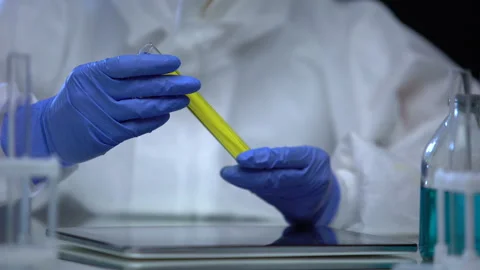 Lab worker in protective suit researching flammable sample of fuel, control Stock Footage 115417285