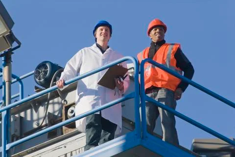 Lab worker standing with an engineer at an asphalt plant Stock Photos
