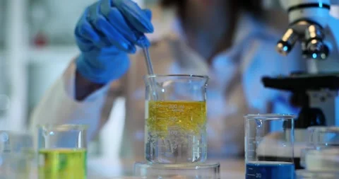 Lab worker stirs liquid with oil in beaker at workplace Stock Footage 279874049