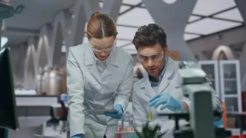 Lab workers experimenting samples looking at computer data in clinic close up Stock Photos