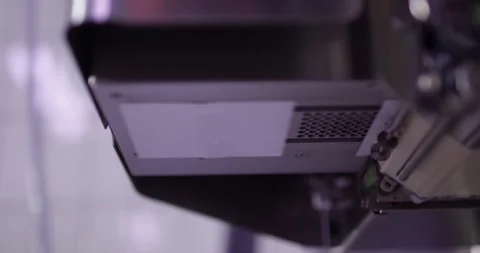 Labeling machine dispensing printed sticker on packaging line, Slow Motion Stock Footage 340016498