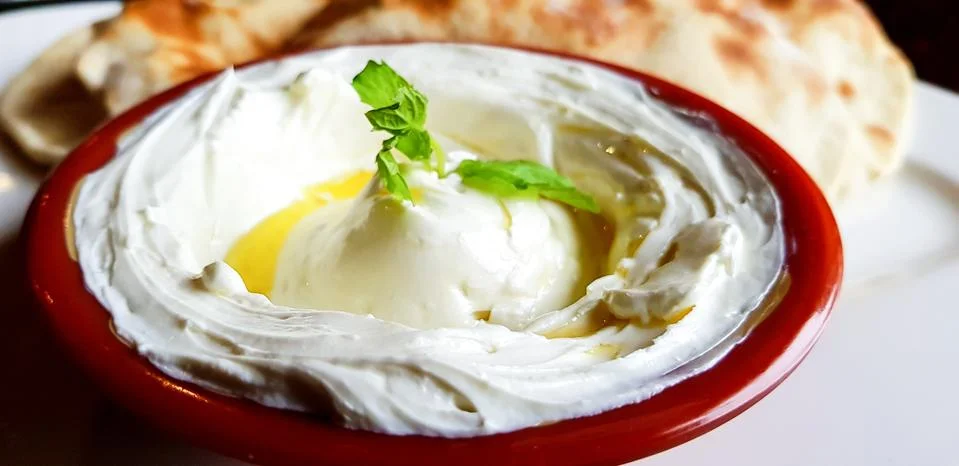 Labneh, thick arab yoghurt cream cheese dip, with mint leaves and olive oil Stock Photos