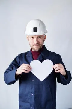 Labor Day concept: engineer in hard hat with white paper heart Stock Photos