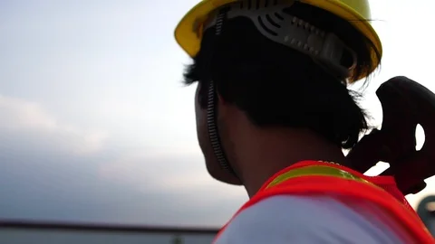 Labor man holding a pipe wrench with the warm light of the Sunset Stock Footage 105912828