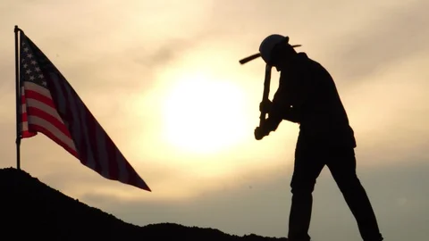 Labor man standing holding a pickaxe with the United States flag Stock Footage 106882367