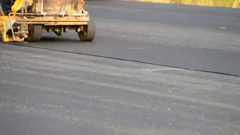 Labor use small machine paint line on road Stock Footage 98247935