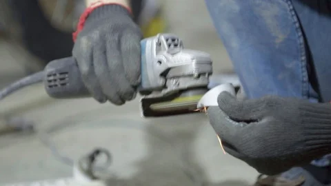 Labor worker sanding pieces of pipe with angle grinder machine Stock Footage 128918982